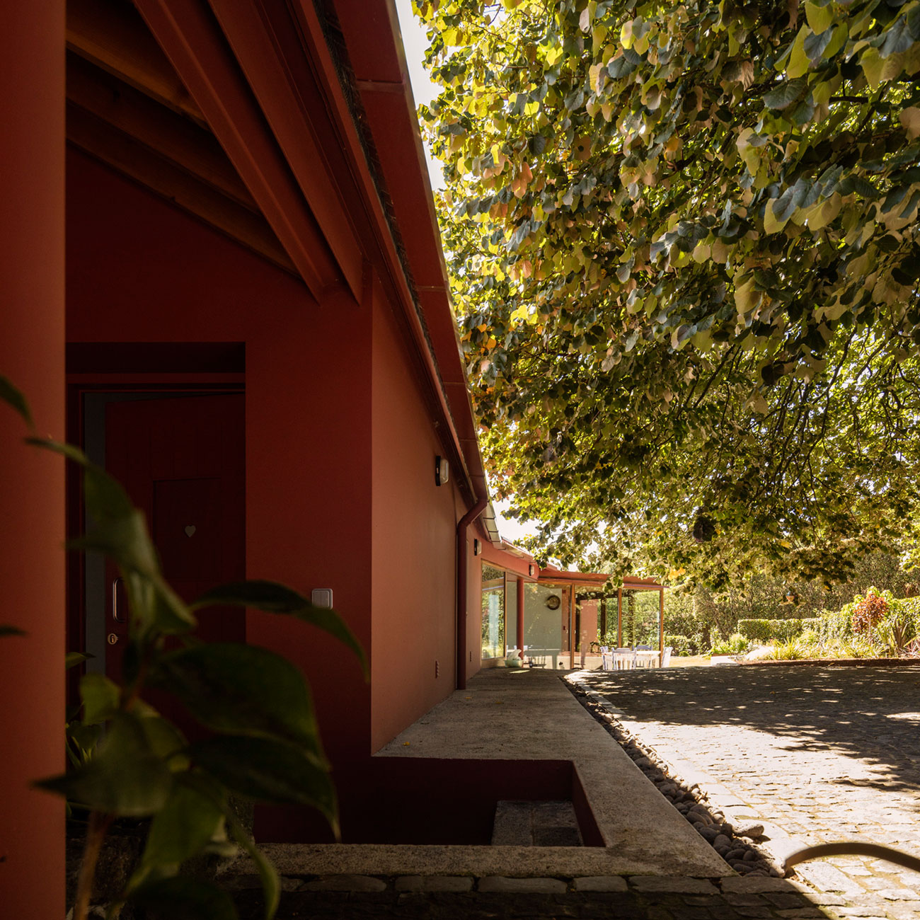 A Bright Contemporary Red Home Consists of Two Volumes Connected by a Wide Corridor in Ponta Delgada by Pedro Mauricio Borges (4)