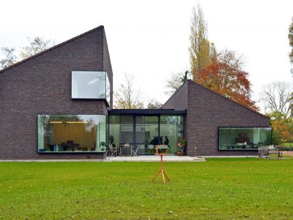 A Luminous House Divided in Two Separate Volumes Surrounded by Vast Green on Aalter, Belgium