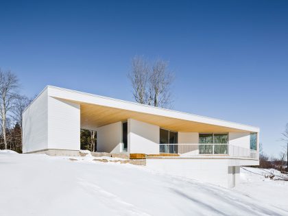 A Beautiful and Luminous Home Perched on the Snowy Terrain in Mansonville, Canada