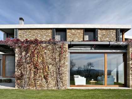 A Modern House with Stone on the Outside and Exposed Concrete on the Inside in El Ampurdán